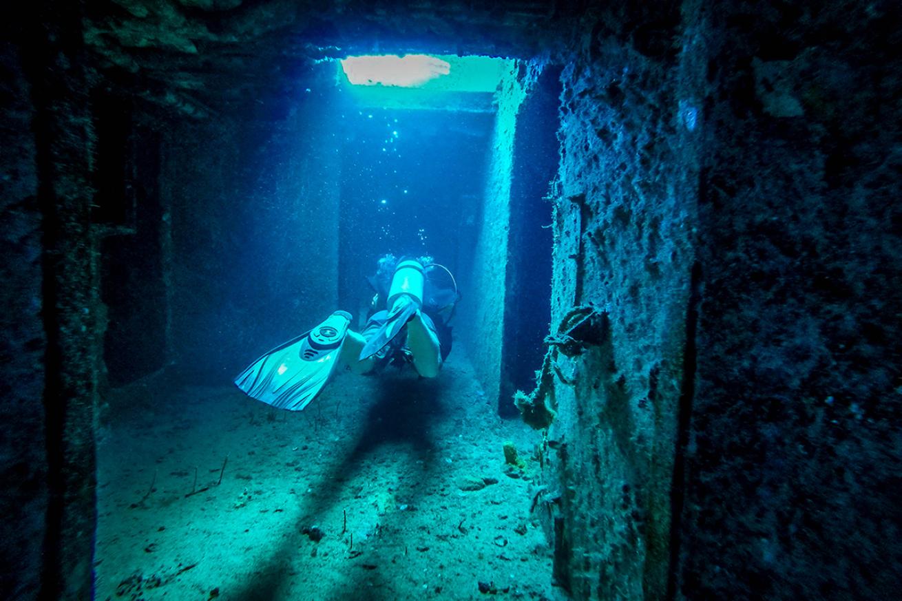 Diver swimming through a wreck