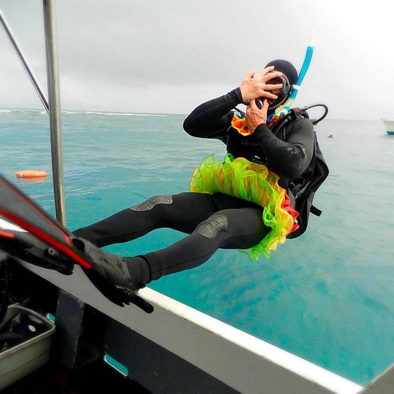 Snorkeler in tutu backrolling off boat