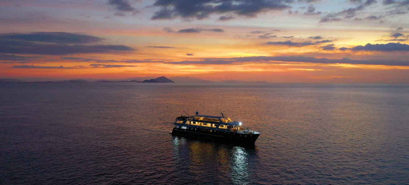 A boat in the water at sunset