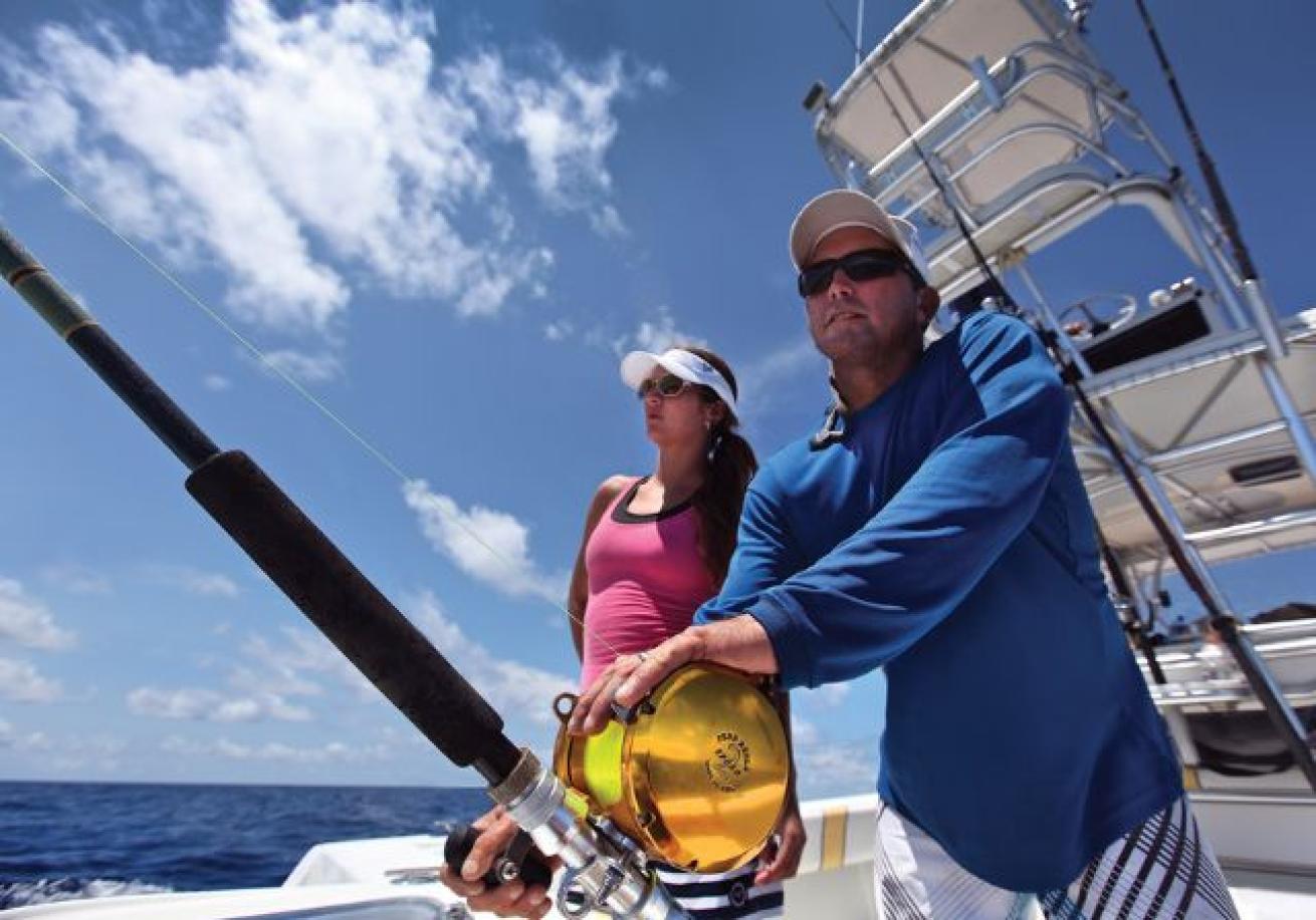 A person and person fishing on a boat