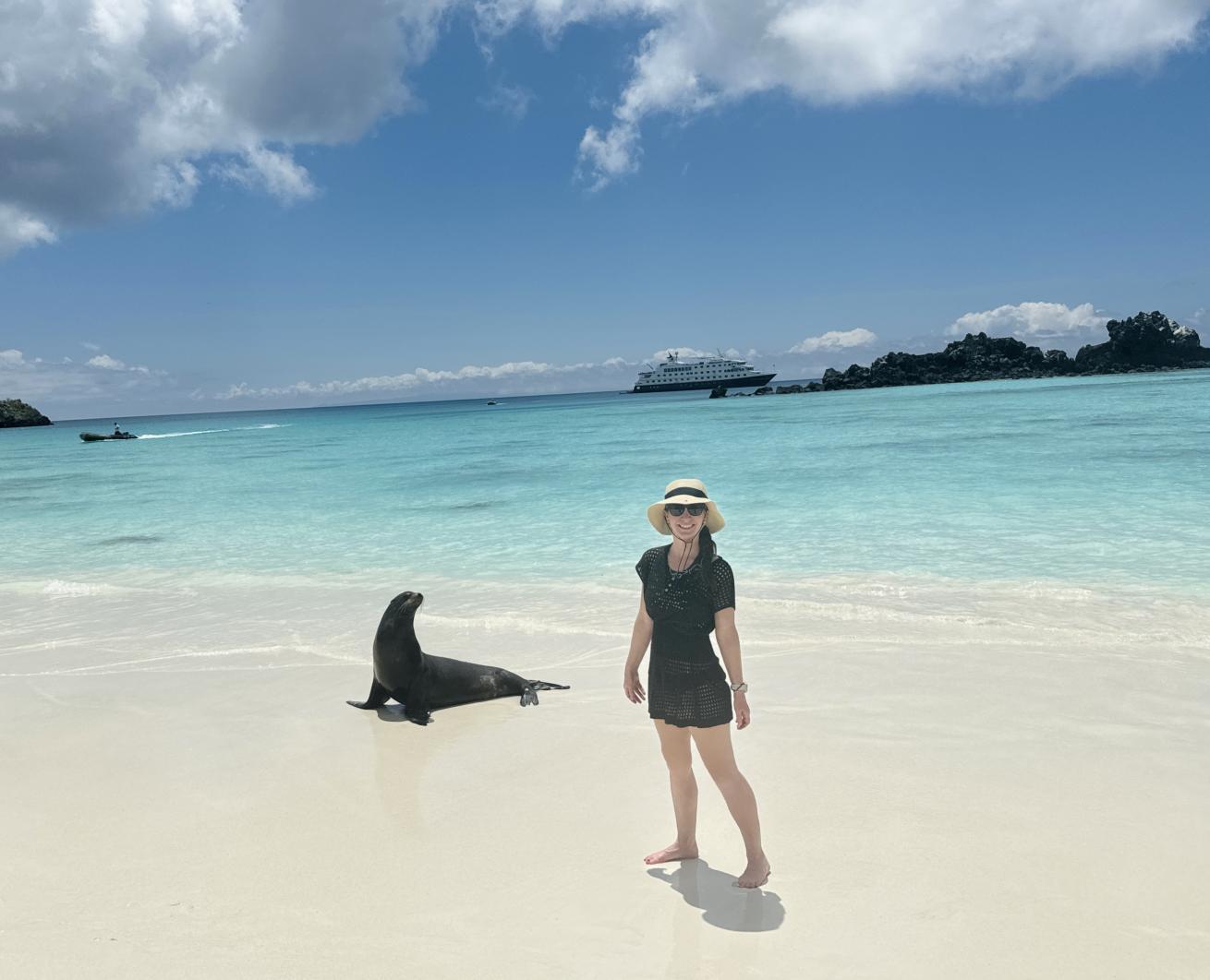 a person poses next to a sea lion in crystal clear water