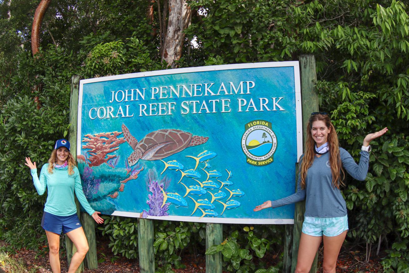 Women standing in front of a sign